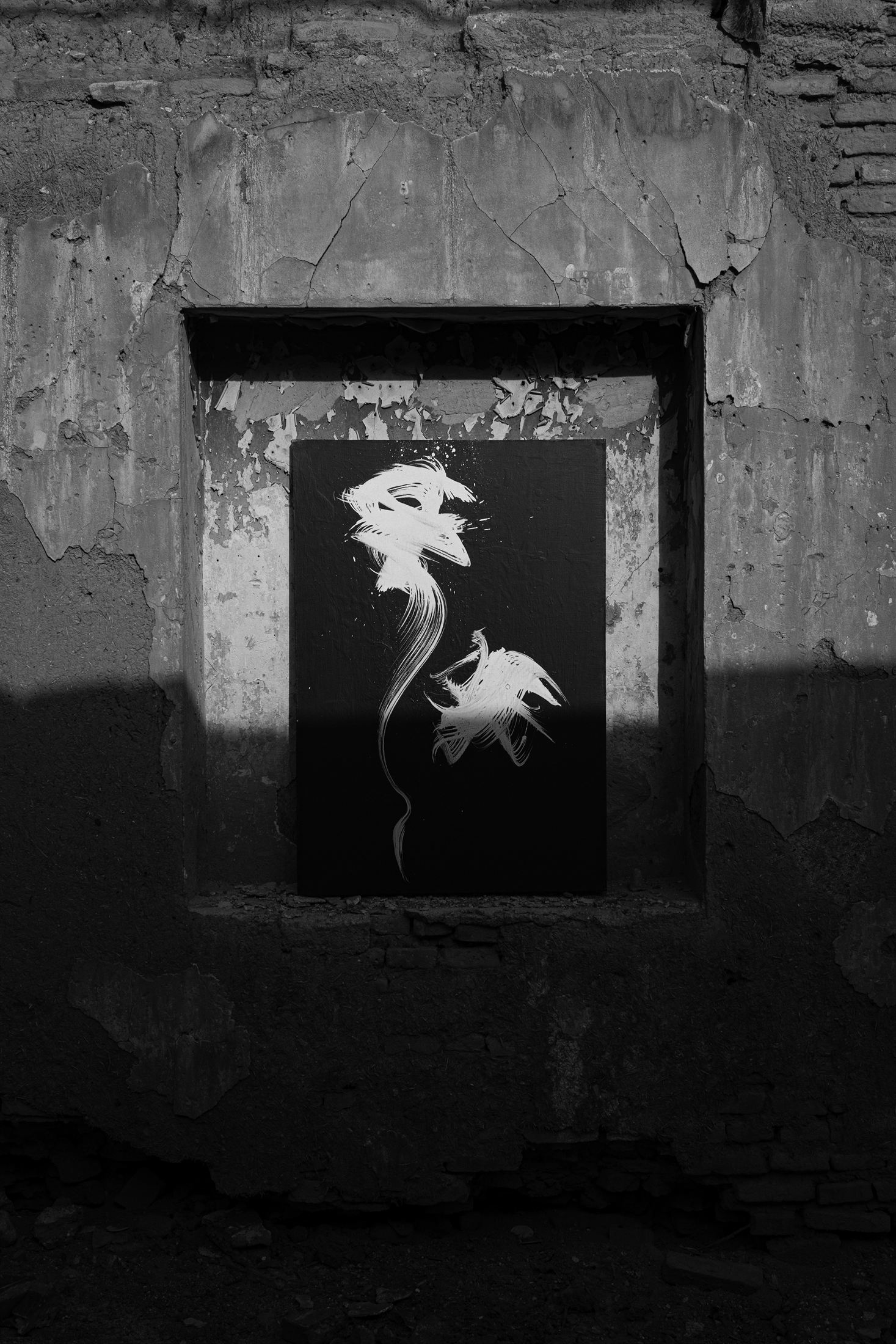 A calligraphic canvas set into a broken window niche, caught in hard sunlight