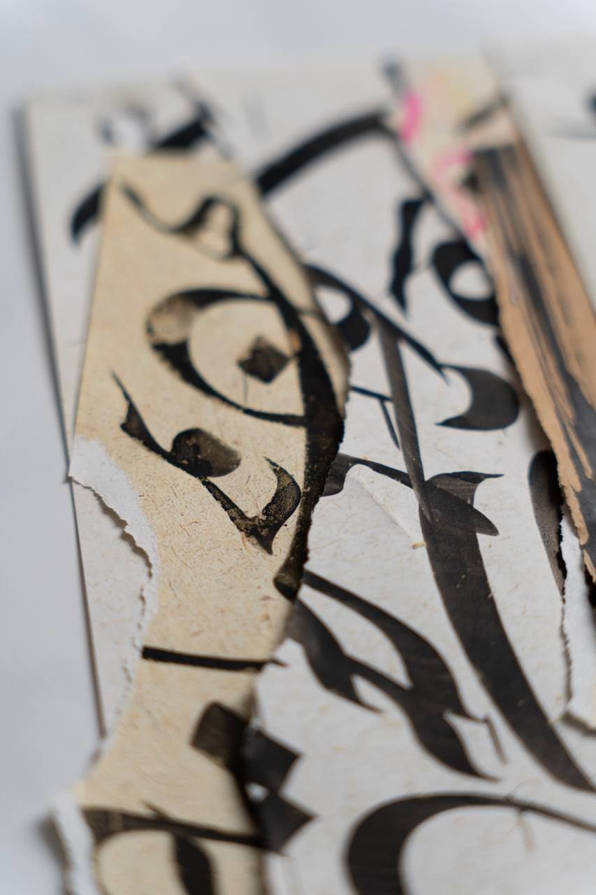 Close detail of torn calligraphy fragments, shallow focus